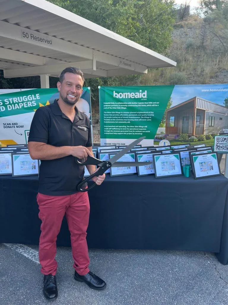A Powered Up Inc. team member at the HomeAid Utah Other Side Village Build Shift ribbon cutting celebration